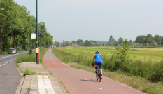 Een fietser op het bestaande fietspad langs de N417 in Maartensdijk waar een zonnefietspad wordt aangelegd.