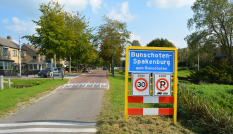 Wegbord van Bunschoten-Spakenburg langs een smalle weg die een woonwijk in loopt
