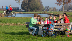 Een gezin zit te eten aan een picknicktafel in Noorderpark-Ruigenhoek