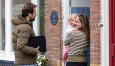 Man staat voor de deur bij vrouw met kind