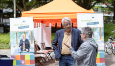 Twee mensen praten voor een stand van Energie in Smitsveen, Soest