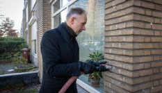 Gedeputeerde Huib van Essen vult spouwmuur met isolatie