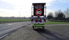Een tekstkar langs de N402 in Loenen met daarop vermeld dat de nieuwe maximumsnelheid 60 km/uur is.