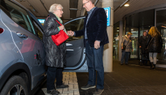 oudere mevrouw wordt geholpen bij uitstappen regiotaxi