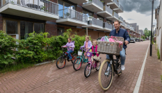 Fietser fietst met drie kinderen door straat