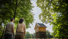 Twee bezoekers kijken naar een hutje op Kamp van Zeist
