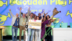 Deelnemers van kern met pit die enthousiast poseren met hun prijs op een podium