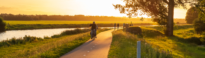 Uitzicht op een fietspad langs de Eem bij zonsondergang