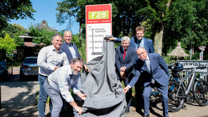 Wethouders Catsburg, Suna, van de Veerdonk, Bijlholt, gedeputeerde van Schie en secretaris-generaal van het ministerie IenW de heer Dronkers onthullen het F28 routebord