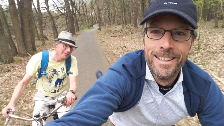 Twee mannen fietsen vrolijk op een bospad