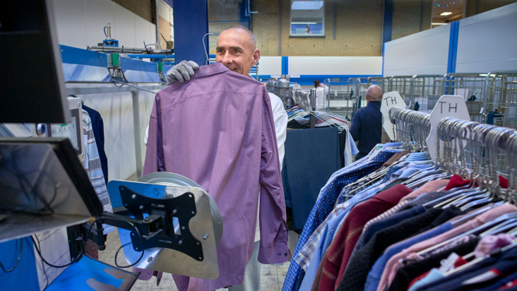 Medewerker Newasco sorteert wasgoed