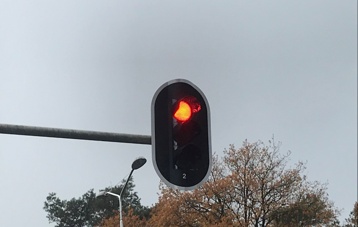 verkeerslicht aan een mast boven de weg