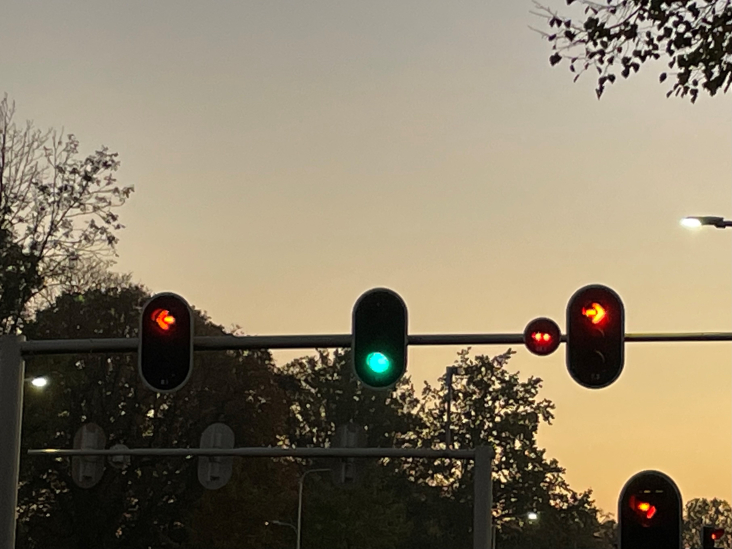 Verkeerslichten boven een weg in het schemerdonker