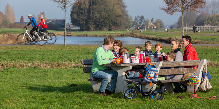 Een gezin zit te eten aan een picknicktafel in Noorderpark-Ruigenhoek