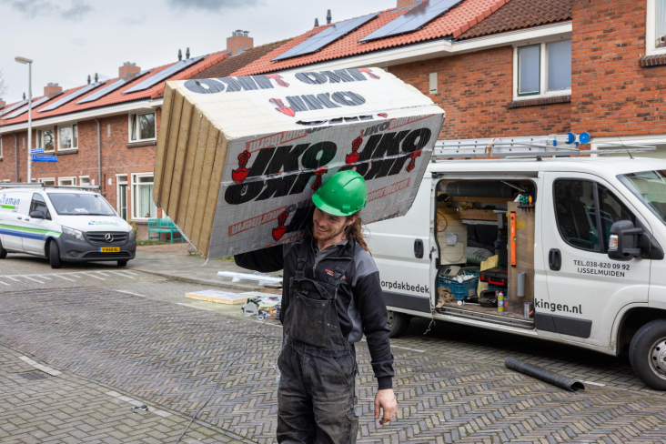 Bouwvakker loopt met pak isolatiemateriaal op schouder, Zuilen Utrecht