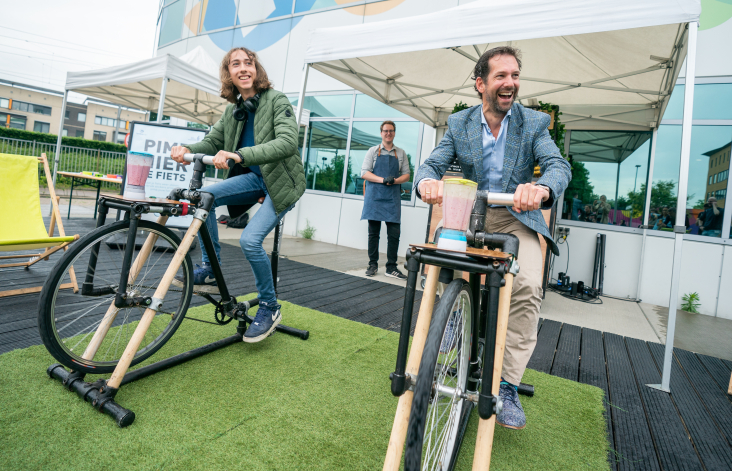 ROC-student Romme Sinon en gedeputeerde Arne Schaddelee op de smoothie fiets