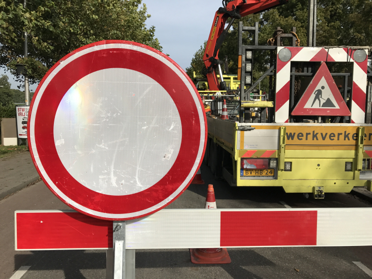 Een wegafsluiting met borden en werkverkeer