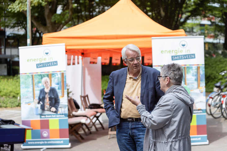 © José Kliphuis Twee mensen praten voor een stand van Energie in Smitsveen, Soest