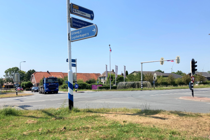 Het kruispunt Graaf op de M.A. Reinaldaweg in Lopik met een wegwijzer op de voorgrond en verkeerslichten.