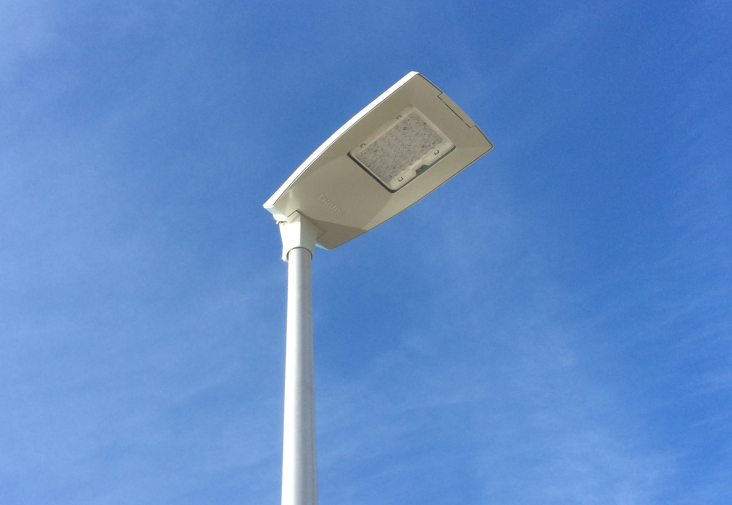 Het bovenste gedeelte van een proviniale lichtmast met ledverlichting, tegen een blauwe lucht.