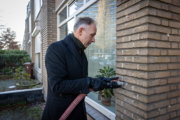 Gedeputeerde Huib van Essen vult spouwmuur met isolatie