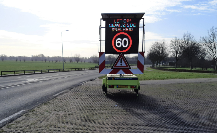 Een tekstkar langs de N402 in Loenen met daarop vermeld dat de nieuwe maximumsnelheid 60 km/uur is.