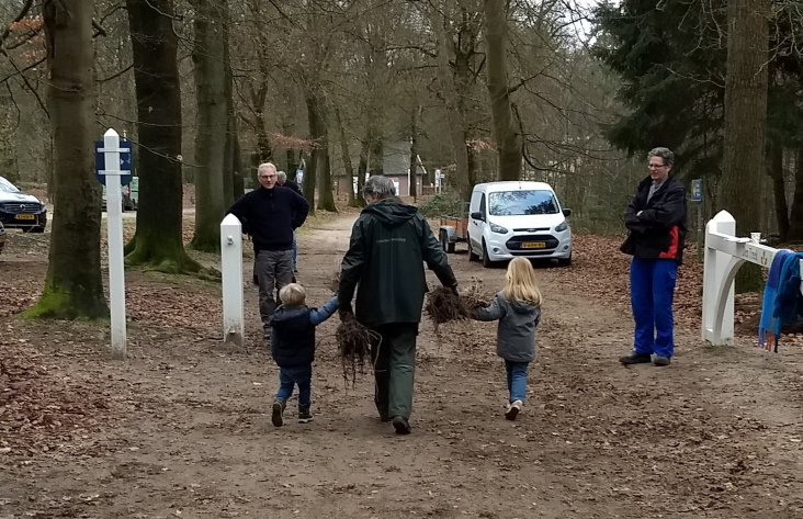 vader met kinderen ontvangen jonge bomen