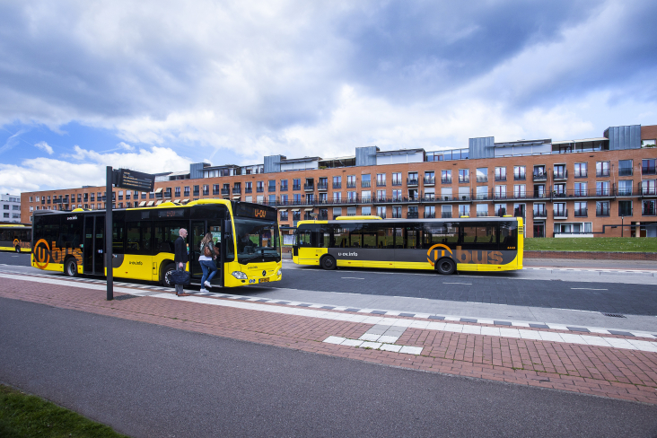 Reizigers bij bushalte stappen in