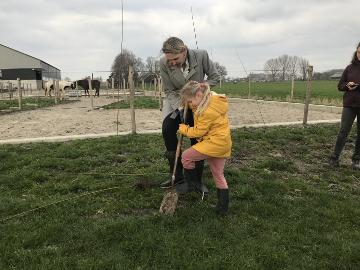 Gedeputeerde Sterk plant samen met jong meisje een Actieplan boom