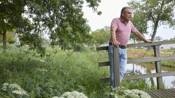 Mark Timmer op bruggetje dat toekomstige groene zone in Nieuw Schaik met natuurgebied verbindt.