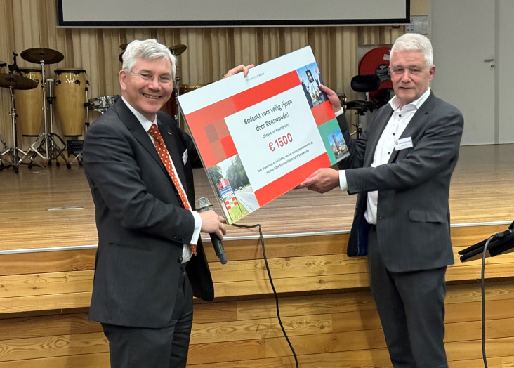 Gedeputeerde Van Schie reikt cheque uit aan wethouder Van der Schoor van Renwoude met de opbrengst van de spaarpaal die op de Dorpsstraat heeft gestaan