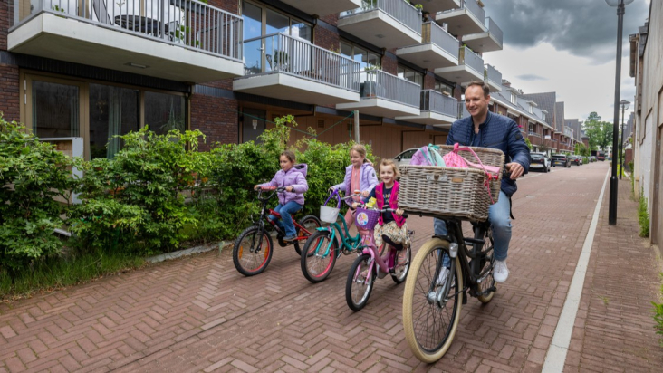 Fietser fietst met drie kinderen door straat