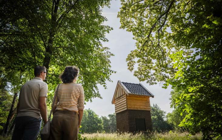 © Freek van den Bergh Twee bezoekers kijken naar een hutje op Kamp van Zeist