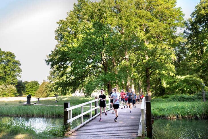 Een groep hardlopers rent door de natuur in Utrecht