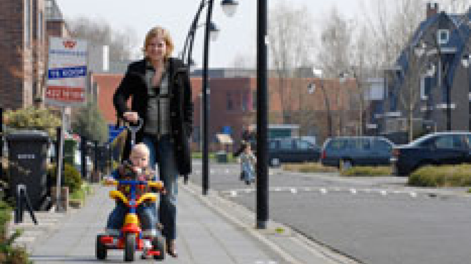Vrouw met kind lopen in nieuwbouwwijk