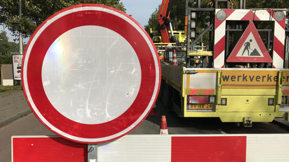 Een wegafsluiting met borden en werkverkeer