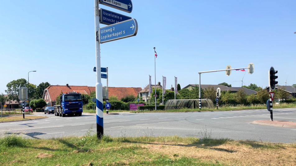 Het kruispunt Graaf op de M.A. Reinaldaweg in Lopik met een wegwijzer op de voorgrond en verkeerslichten.