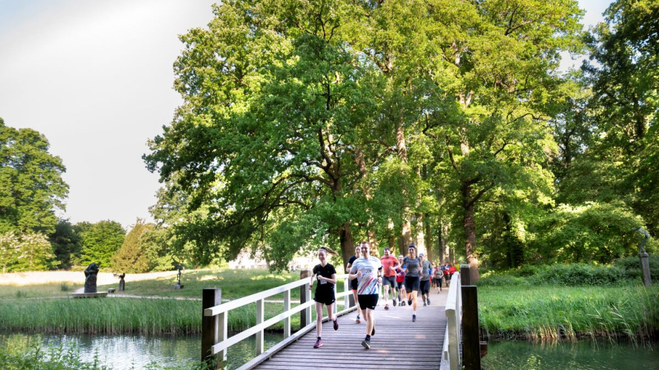 Een groep hardlopers rent door de natuur in Utrecht